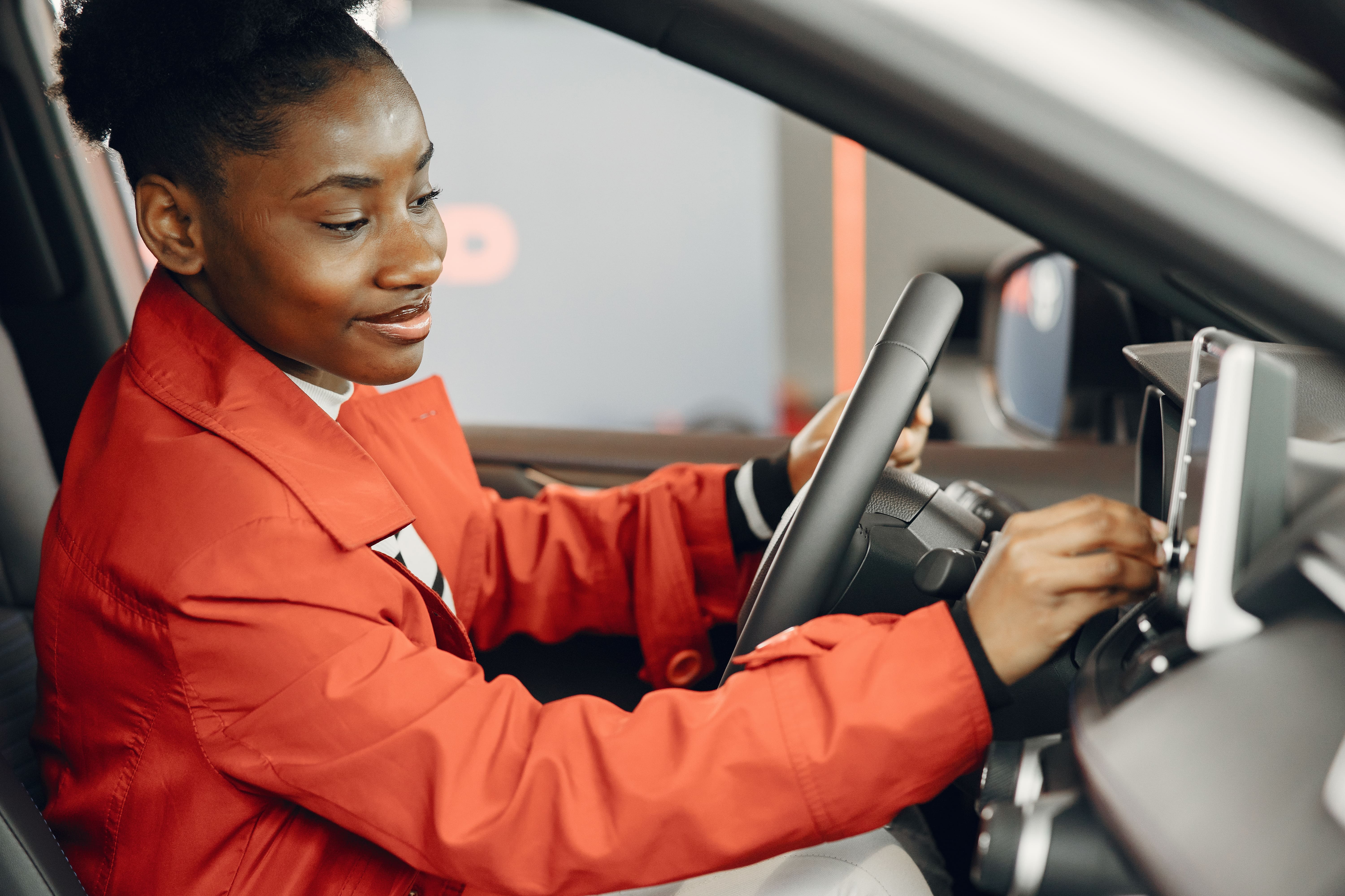 Black Female Driver wearing orange blouse going shopping with car keys in hand